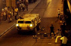 An armoured vehicle crash through a barrier during a protest in Cairo