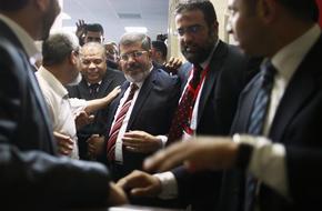 Muslim Brotherhood's presidential candidate Mohamed Morsy leaves after a news conference in Cairo
