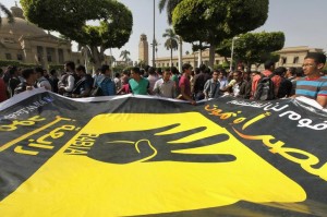 Cairo university students and members of the Muslim Brotherhood carry a banner with symbol of Rabaa during protest against military in Cairo