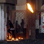 Students of Al-Azhar University, who are supporters of Muslim Brotherhood and deposed President Mursi, are seen as a Molotov cocktail is thrown by one of students at riot police and residents of area during clashes at university campus in Cairo