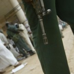 A Sudanese man passes an armed policeman