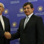 Iran's Foreign Minister Zarif shakes hands with his Turkish counterpart Davutoglu during a joint news conference in Istanbul