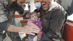 A man holds his child after he was pulled out from under the rubble at a site hit by what activists say was an air strike in Daiaat Al-Ansari neighborhood, Aleppo