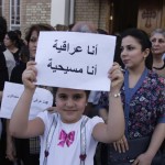A girl holds up a sign that reads: "I am an Iraqi, I am a Christian" at Mar Girgis Church in Baghdad