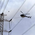 A helicopter cools down an electric tower on a hot day at the Imbaba area in Cairo