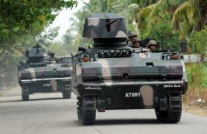 Soldiers aboard armoured vehicles patrol a highway in Mamasapano