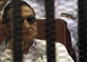 Egypt's ousted President Hosni Mubarak sits inside a dock at the police academy, on the outskirts of Cairo