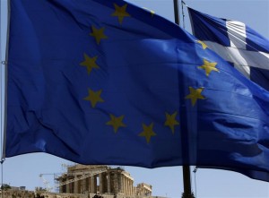A E.U. flag and a Greek flag flutter in front of the monument of Parthenon on Acropolis hill in Athen