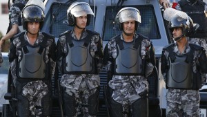 Riot police stand guard near the Israeli embassy in Amman
