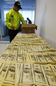 A police officer displays seized counterfeit dollars for the media, in Cali October 9, 2012. Colombian police on Monday seized at least 1.5 million worth of counterfeit dollars. REUTERS/Jaime Saldarriaga (COLOMBIA - Tags: CRIME LAW)