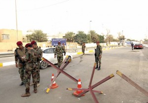 Iraqi security forces gather at a checkpoint as cars cross into the Green Zone in Baghdad, Iraq October 5, 2015. Iraqi Prime Minister Haider al-Abadi declared the heavily fortified Green Zone in central Baghdad open to all citizens on Sunday, part of a reform drive prompted by protests demanding greater transparency and openness. The 10-square-kilometre (four-square-mile) Green Zone on the bank of the Tigris River has been largely off limits to ordinary Iraqis due to security concerns since the 2003 U.S. invasion that ousted Saddam Hussein. The zone, which houses government buildings and foreign embassies including that of the United States, has come to symbolise the isolation of Iraq's rulers from citizens and also causes considerable traffic disruption in the city of seven million people. REUTERS/Ahmed Saad