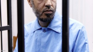 Saadi Kadhafi, the son of slain Libyan dictator Moamer Kadhafi, sits, dressed in prison blues, behind the accused cell during his trial in a courthouse in the Libyan capital Tripoli on November 1, 2015. Saadi is charged with the first-degree murder, in 2005, of a former trainer at Tripoli's Al-Ittihad football club. AFP PHOTO / MAHMUD TURKIA        (Photo credit should read MAHMUD TURKIA/AFP/Getty Images)