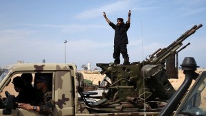 A fighter from Misrata shouts to his comrades as they move to fight Islamic State militants near Sirte March 15, 2015. Militants loyal to Islamic State, the group which has seized much of Iraq and Syria, have established a larger presence in central Libya in recent weeks. Islamic State, which analysts say is splintered into smaller factions in Libya, has sought to exploit turmoil in the major oil producer where two rival governments and their respective allies fight for power.    REUTERS/Goran Tomasevic (LIBYA - Tags: CIVIL UNREST POLITICS) - RTR4TEZI
