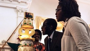 Zimbabwe President Robert Mugabe (C), flanked by his wife Grace Mugabe (L) and daughter Bona (R), blows candles on his cake during a suprise party  hosted by the office of the President and Cabinet at State House in Harare, on February 22, 2016 to celebrate his 92nd birthday.  Zimbabwean President becomes the worlds oldest leader with no plans to step down as feuding over his successors threatens to tear his ruling ZANU-PF apart. / AFP / JEKESAI NJIKIZANA        (Photo credit should read JEKESAI NJIKIZANA/AFP/Getty Images)