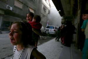 Ghazal, 4, (L) and Judy, 7, carrying 8-month-old Suhair, react after what activists said was shelling by forces loyal to Syria's President Bashar al-Assad near the Syrian Arab Red Crescent centre in the Douma neighborhood of Damascus, in this file picture taken May 6, 2015. European Union leaders meet on March 7, 2016 to debate how to end the migrant crisis before a second summer of chaos, but they have already long known the available answers -- and why they have yet to add up to a solution.     REUTERS/Bassam Khabieh/Files