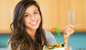 Portrait of beautiful young woman eating a bowl of healthy organ