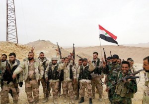 Forces loyal to Syria's President Bashar al-Assad flash victory signs and carry a Syrian national flag on the edge of the historic city of Palmyra in this handout picture provided by SANA on March 26, 2016. REUTERS/SANA/Handout via Reuters ATTENTION EDITORS - THIS PICTURE WAS PROVIDED BY A THIRD PARTY. REUTERS IS UNABLE TO INDEPENDENTLY VERIFY THE AUTHENTICITY, CONTENT, LOCATION OR DATE OF THIS IMAGE. FOR EDITORIAL USE ONLY. NOT FOR SALE FOR MARKETING OR ADVERTISING CAMPAIGNS. THIS PICTURE IS DISTRIBUTED EXACTLY AS RECEIVED BY REUTERS, AS A SERVICE TO CLIENTS