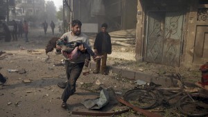 A man carries an injured girl as he rushes away from a site hit by what activists said were airstrikes by forces loyal to Syria's President Bashar al-Assad, in the Douma neighborhood of Damascus, Syria November 7, 2015. REUTERS/Bassam Khabieh        TPX IMAGES OF THE DAY